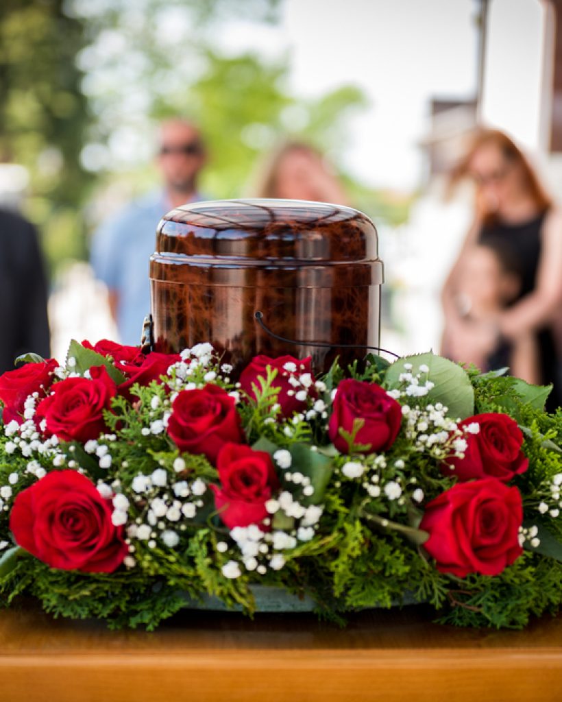 Funerary,Urn,With,Ashes,Of,Dead,And,Flowers,At,Funeral.